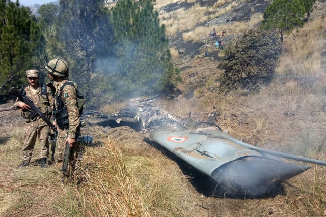 TOPSHOT - Pakistani soldiers stand next to what Pakistan says is the wreckage of an Indian