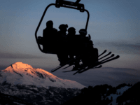 TOPSHOT - Skiers are seen in silhouette on a ski lift as the sun rises next the resort of Lenzerheide, eastern Switzerland, on January 28, 2018. (Photo by Fabrice COFFRINI / AFP) (Photo credit should read FABRICE COFFRINI/AFP/Getty Images)