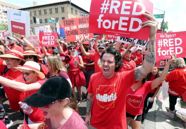 PHOENIX, AZ - APRIL 26: Thousands of Arizona teachers march through downtown Phoenix on their way to the State Capitol as part of a rally for the #REDforED movement on April 26, 2018 in Phoenix, Arizona. Teachers state-wide staged a walkout strike on Thursday in support of better wages and …