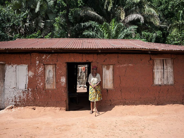 An elderly woman stands outside her house on May 5, 2016 in Nimbo, southeastern Nigeria, w