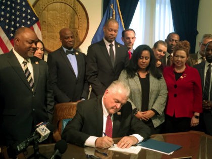 Nevada Gov. Steve Sisolak surrounded by lawmakers who supported gun control, signs legislation expanding background checks to private gun sales and transfers in Carson City, Nev., Friday, Feb. 15, 2019. Gov. Sisolak signed into law a measure closing a loophole that allows gun buyers to avoid background checks by going …