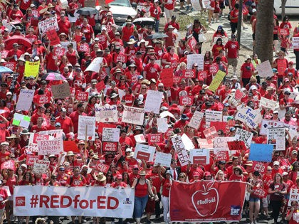Arizona teachers march through downtown Phoenix on their way to the State Capitol on April 26, 2018 in Phoenix, Arizona. Teachers state-wide staged a walkout strike on Thursday in support of better wages and state funding for public schools. (Photo by Ralph Freso/Getty Images)