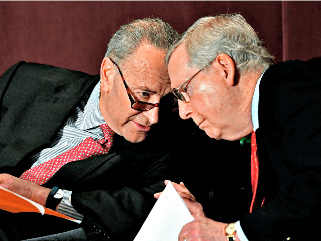 Senate Minority Leader Charles Schumer, D-N.Y., left, leans in to speak to Senate Majority Leader Mitch McConnell, R-Ky., before his speech at the McConnell Center's Distinguished Speaker Series Monday, Feb. 12, 2018, in Louisville, Ky. (AP Photo/Timothy D. Easley