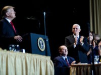 US Senator Christopher Coons (Seated), US Vice President Mike Pence (C), and others clap for US President Donald Trump during the National Prayer Breakfast on February 7, 2019 in Washington, DC. (Photo by Brendan Smialowski / AFP) (Photo credit should read BRENDAN SMIALOWSKI/AFP/Getty Images)