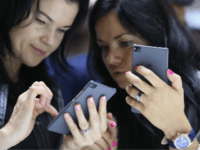 Women trying Huawei phones BERLIN, GERMANY - SEPTEMBER 04: Visitors try out the Honor 7 smartphone at the Huawei stand at the 2015 IFA consumer electronics and appliances trade fair on September 4, 2015 in Berlin, Germany. The 2015 IFA will be open to the public from September 4-9. (Photo by Sean Gallup/Getty Images)