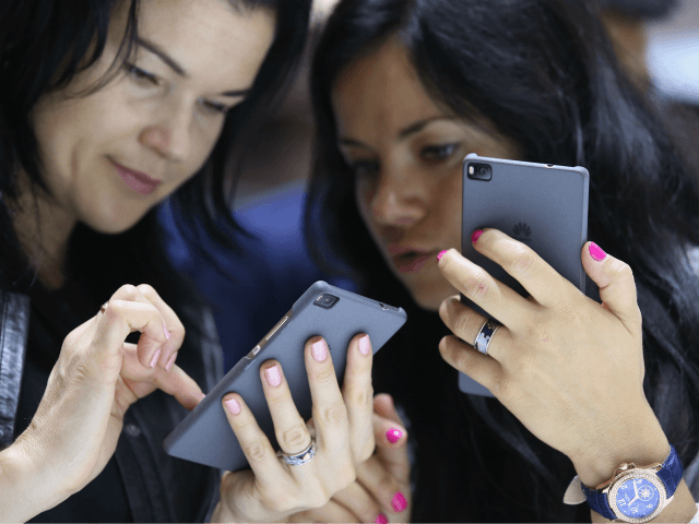 BERLIN, GERMANY - SEPTEMBER 04: Visitors try out the Honor 7 smartphone at the Huawei stand at the 2015 IFA consumer electronics and appliances trade fair on September 4, 2015 in Berlin, Germany. The 2015 IFA will be open to the public from September 4-9. (Photo by Sean Gallup/Getty Images)