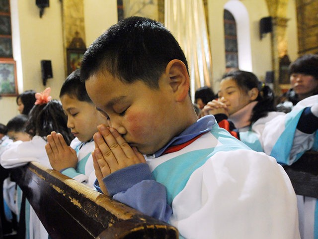 This picture taken on December 24, 2012 shows young Chinese congregation members praying d