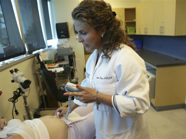 In this Tuesday, Aug. 2, 2016 file photo, nurse practitioner Juliana Duque uses a fetal heart monitor on a patient who is in her first trimester of pregnancy at the Borinquen Medical Center, in Miami. The CDC has advised pregnant women to avoid travel to the nearby neighborhood of Wynwood â¦
