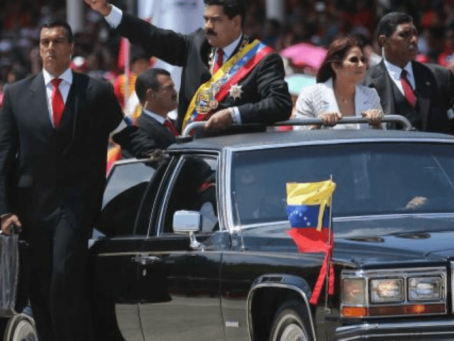 Venezuelan president Nicolas Maduro (C) and firts lady Cilia Flores (2-R) greets supporters before a military parade in Caracas on March 5, 2014. The Venezuelan government on Wednesday commemorated the first anniversary of the death of President Hugo Chávez with a civic-military parade in Caracas Avenue West, accompanied by Latin …