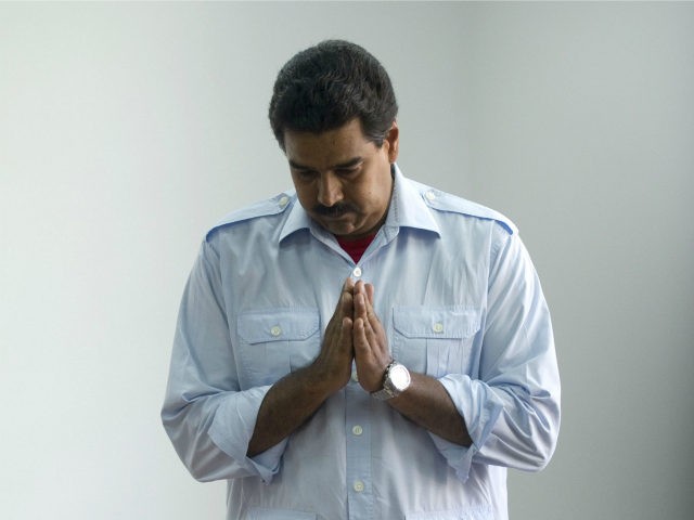 Venezuelan acting president and presidential candidate Nicolas Maduro assumes a praying at