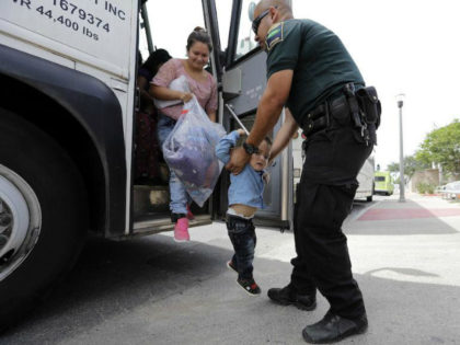 A transport officer, right, helps immigrants Dilma Araceley Riveria Hernandez, and her son, Anderson Alvarado, 2, get off the bus after they were processed and released by U.S. Customs and Border Protection, Sunday, June 24, 2018, in McAllen, Texas. (AP Photo/David J. Phillip)