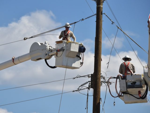 Workers repair power lines in Panama City, Florida, on October 14, 2018. - Four days after