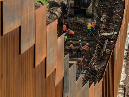 TOPSHOT - Workers reinforce a section of the US-Mexico border fence, as seen from eastern