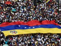 Opposition activists display a Venezuelan flag as they pour to the streets to back Venezuelan opposition leader Juan Guaido's calls for early elections, in Caracas on February 2, 2019 Rival rallies begin in tense Venezuela as air force general defects
