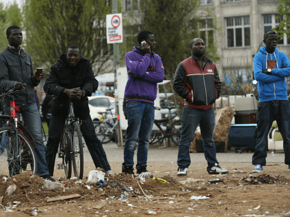 BERLIN, GERMANY - APRIL 08: Refugees from Africa watch as other tear down their huts at a