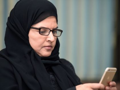 Saudi activist and campaigner Aziza al-Yousef checks her mobile phone during an interview in the capital Riyadh, on September 27, 2016. Thousands of Saudis have signed a petition urging an end to the guardianship system giving men control over the work, study, marriage and travel of female relatives, activists said. …
