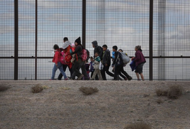EL PASO, TEXAS - FEBRUARY 01: Central American immigrants walk along the border fence after crossing the Rio Grande from Mexico on February 01, 2019 in El Paso, Texas. The migrants later turned themselves in to U.S. Border Patrol agents, seeking political asylum in the United States. (Photo by John …