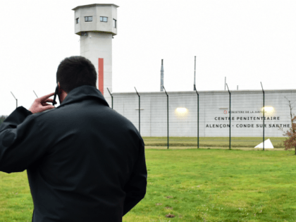 A member of the 'Regional Response and Security Teams' (ERIS), who replaces staff members on strike, speaks on the telephone as prison guards block the entrance to the penitentiary center of Alencon, in Conde-sur-Sarthe, northwestern France, on early March 6, 2019, a day after a prison inmate seriously wounded two …