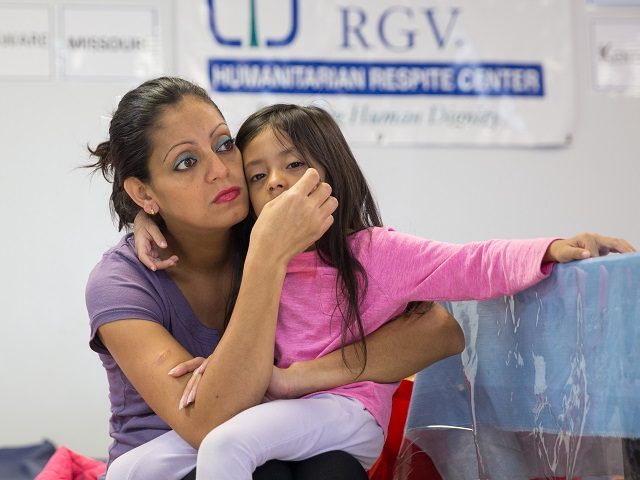 A woman from Honduras and her 4-year-old daughter seeking asylum sit at a Catholic Charities relief center on Sunday, June 17, 2018 in McAllen, Texas. - People went to the center for assistance after being released from detention through "catch and release" immigration policy. (Photo by Loren ELLIOTT / AFP) …