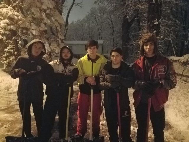 High school seniors shovel neighbor's driveway.