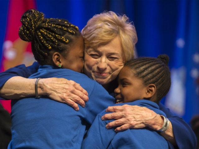 Gov. Janet Mills hugs two young singers during her inauguration ceremony, Wednesday, Jan. 2, 2019, at the Augusta Civic Center in Augusta, Maine. Mills, a Democrat, is the state's first female governor. (AP Photo/Robert F. Bukaty)