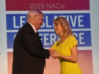 Greg Cox, president of the National Association of Counties, thanks Kellyanne Conway, senior adviser to President Donald Trump, for speaking at the organization's annual legislative conference in Washington, DC, on Monday.