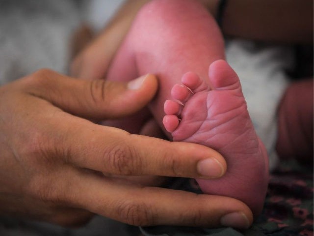 A mother holds the foot of her newborn baby on July 7, 2018 at the hospital in Nantes, western France.