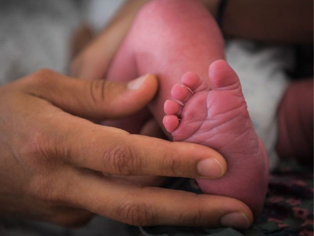 A mother holds the foot of her newborn baby on July 7, 2018 at the hospital in Nantes, wes