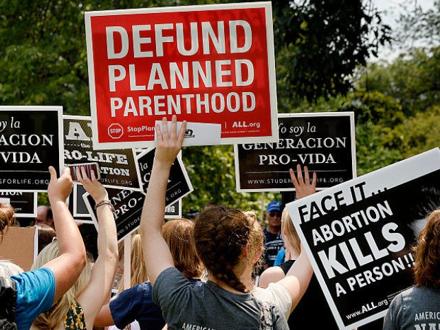 Anti-abortion activists hold a rally opposing federal funding for Planned Parenthood in fr