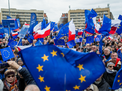 People wave EU and Polish flags during a demonstration of the Committee for Democracy Defe