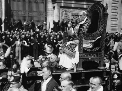 Pope Pius XII (1876 - 1958), Eugenio Pacelli, being carried through a crowded piazza. (Pho