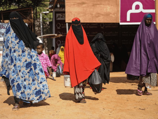 Somali internally displaced people (IDPs) receive food distribution in Mogadishu, Somalia, on May 22, 2018. - About 800 internally displaced people from 8 camps in Mogadishu receive Iftar dinner, the first meal after the daytime fast during the month of Ramadan, at food distribution centre annually installed during Ramadan by …