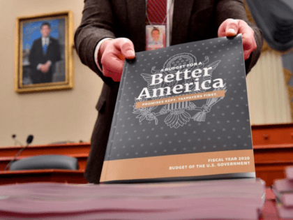 A Senate staff member displays a copy of volume one of President Trump's fiscal year 2020