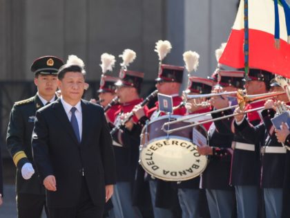 Italian President Sergio Mattarella (L) and Chinese President Xi Jinping (C) review a Hono