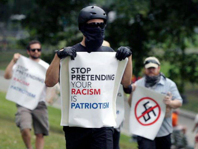 Counterprotesters hold signs before conservative organizers begin a planned "Free Speech" rally on Boston Common, Saturday, Aug. 19, 2017, in Boston. Police Commissioner William Evans said Friday that 500 officers, some in uniform, others undercover, would be deployed to keep the two groups apart. (AP Photo/Michael Dwyer)