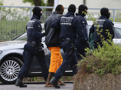ELLWANGEN, GERMANY - MAY 03: Police and an arrested refugee are seen at the main refugee center during an intervention there by riot police on May 3, 2018 in Ellwangen, Germany. Police raided the facility earlier this morning following a confrontation between police and mostly African refugees four days ago …