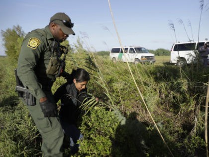 FILE - In this Aug. 11, 2017, file photo a U.S. Customs and Border Patrol agent escorts an immigrant suspected of crossing into the United States illegally along the Rio Grande near Granjeno, Texas. The U.S. government posted a seventh straight monthly increase in people being arrested or denied entry …