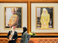 Two woman walk past portraits of Brunei Sultan Hassanal Bolkiah (L) and Queen Saleha (R) at the prime minister's complex in Bandar Seri Begawan on April 24, 2013 ahead of the start of the Association of Southeast Asian Nations (ASEAN) summit. Southeast Asian leaders are meeting in Brunei hoping to …