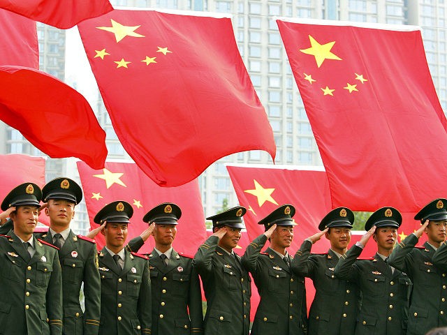 This photo taken 03 October, 2007 shows military officers saluting for a group photo beneath a display of national flags at a park in Beijing. China's ruling Communist Party's five-yearly gathering, it's 17th Party Congress, begins 15 October with President Hu Jintao expected to make bold power plays to cement …