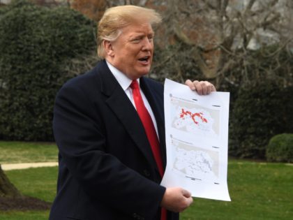 US President Donald Trump holds up a map as he speaks before departing the White House in Washington, DC, on March 20, 2019. (Photo by Jim WATSON / AFP) (Photo credit should read JIM WATSON/AFP/Getty Images)