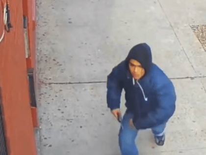 The suspect, wearing a navy hoodie, can be seen pulling out his firearm and aiming it at a
