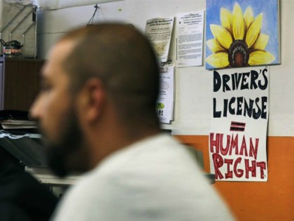 Activists gather, with a sign stating "Drivers License = Human Right" on the wall, during a community meeting at the Olneyville Neighborhood Association, Tuesday, Sept. 20, 2016, in Providence, Rhode Island. Immigrant activists are planning a church-to-church march through a cluster of Rhode Island cities in response to years of …