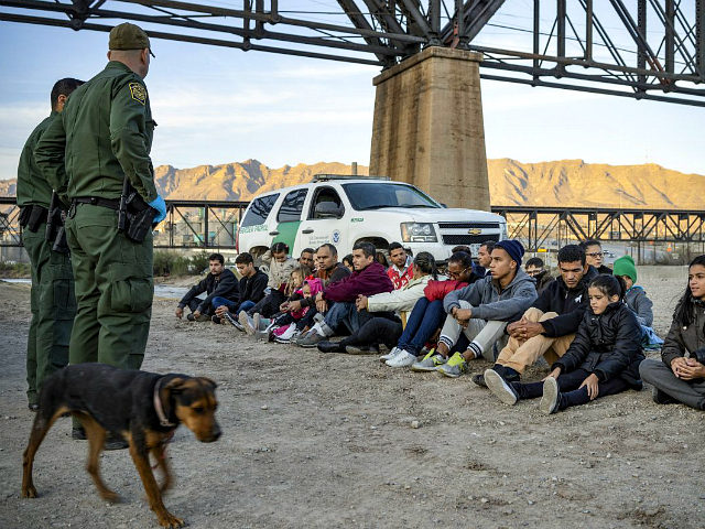 A group of about 30 Brazilian migrants, who had just crossed the border, sit on the ground near US Border Patrol agents, on the property of Jeff Allen, who used to run a brick factory near Mt. Christo Rey on the US-Mexico border in Sunland Park, New Mexico on March …