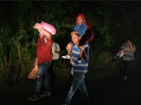 A man carries a child on his shoulders as Honduran migrants, part of the second caravan to the United States, leave San Pedro Sula, 180 km north of Tegucigalpa, on January 14, 2019. - President Donald Trump is threatening to declare a national emergency as he pressures Congress for money …