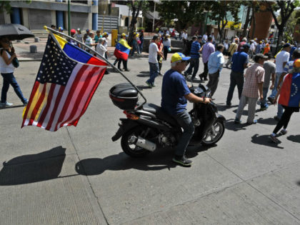 motorcyclist-u.s.-venezuela-flags-getty A supporter of Venezuelan opposition leader and self-proclaimed acting president Juan Guaido rides a motorcycle with A Venezuelan and a US flag during a demo as Guaido is expected to return in Caracas on March 4, 2019. - Opposition supporters in Venezuela were set to take to the streets Monday …