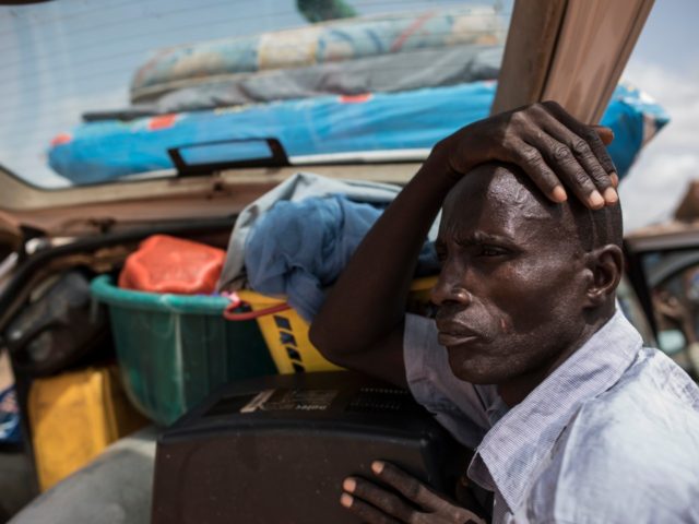 TOPSHOT - A man stands by his possessions as Christian villagers evacuate the Ganaropp village in the Barikin Ladi area near Jos on June 27, 2018. - Plateau State in Nigeria has seen days of violence where more than 200 people have been killed in clashes between Berom farmers and …