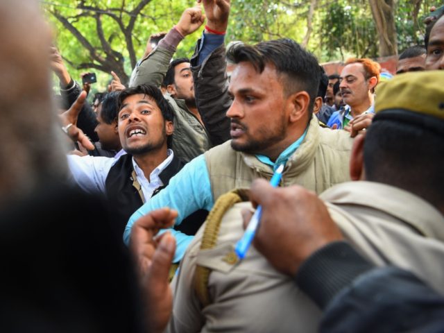 Indian protesters try to push their way through policemen guarding an injured man who had been attacked after a mob believed he was a Kashmiri who had shouted pro-Pakistan slogans, in New Delhi on February 17, 2019. - Protesters in the Indian capital on February 17 beat up a man …