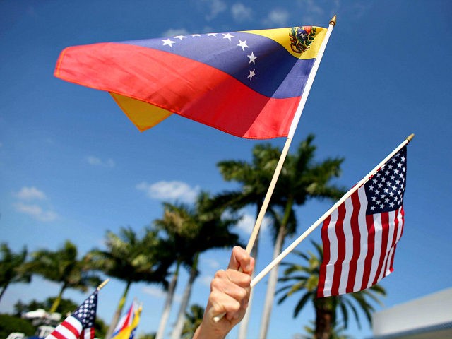 MIAMI, FL - MARCH 01: A protester holds a Venezuelan and American flag as she and other Ve