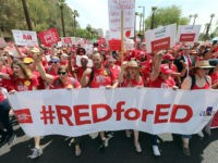 Thousands of Arizona teachers march through downtown Phoenix on their way to the State Capitol as part of a rally for the #REDforED movement on April 26, 2018 in Phoenix, Arizona. Teachers state-wide staged a walkout strike on Thursday in support of better wages and state funding for public schools. …