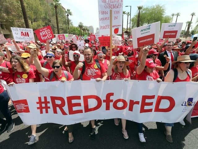 Thousands of Arizona teachers march through downtown Phoenix on their way to the State Capitol as part of a rally for the #REDforED movement on April 26, 2018 in Phoenix, Arizona. Teachers state-wide staged a walkout strike on Thursday in support of better wages and state funding for public schools. …